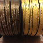 Tira de cuero plano oro viejo y oro con dos pespuntes.