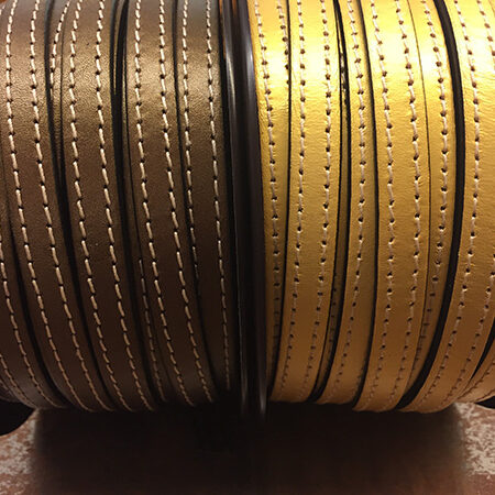 Tira de cuero plano oro viejo y oro con dos pespuntes.